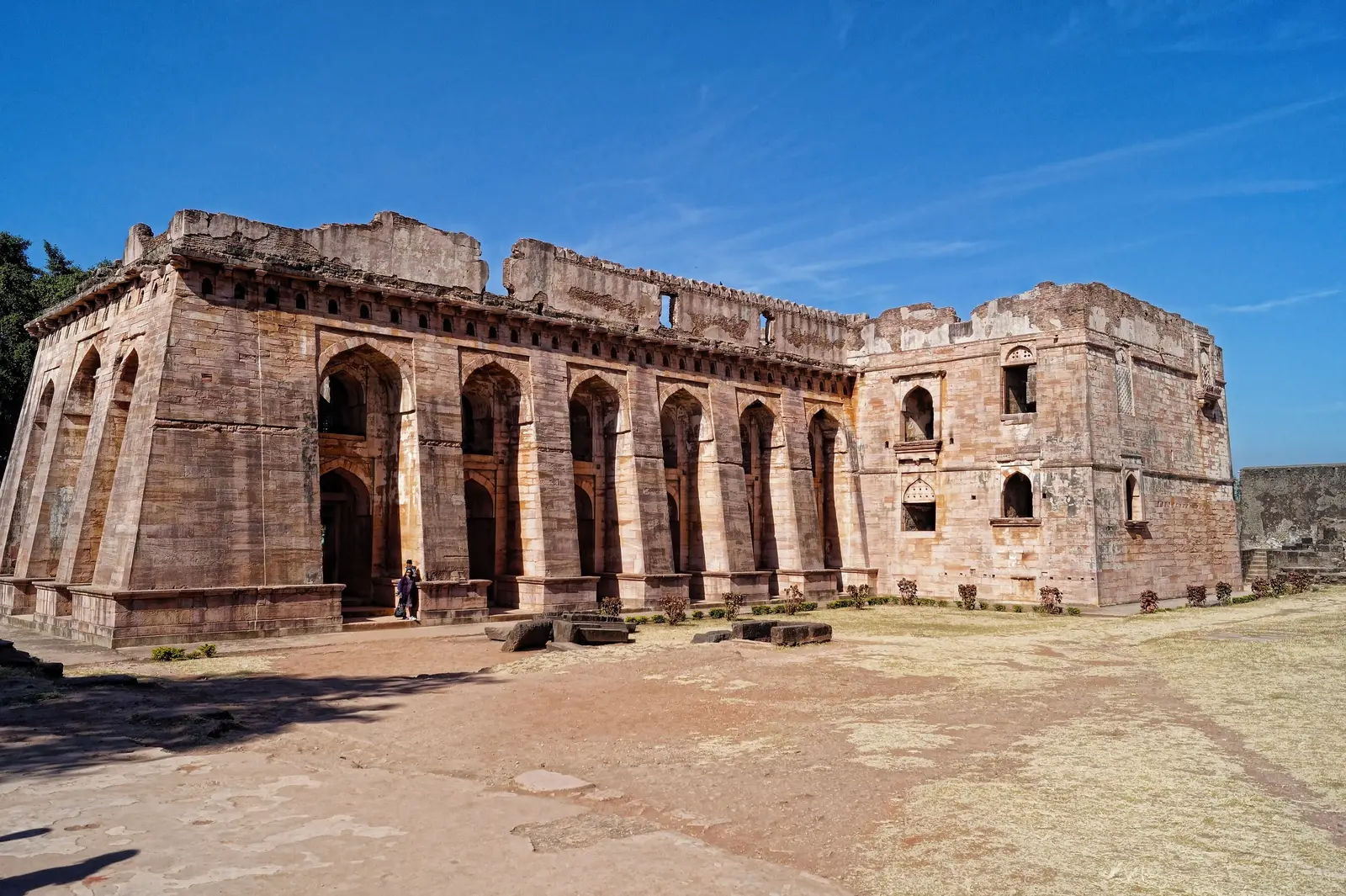 Hindola Mahal in Mandu, a long sandstone hall with steeply sloping buttressed side walls and tall arched openings