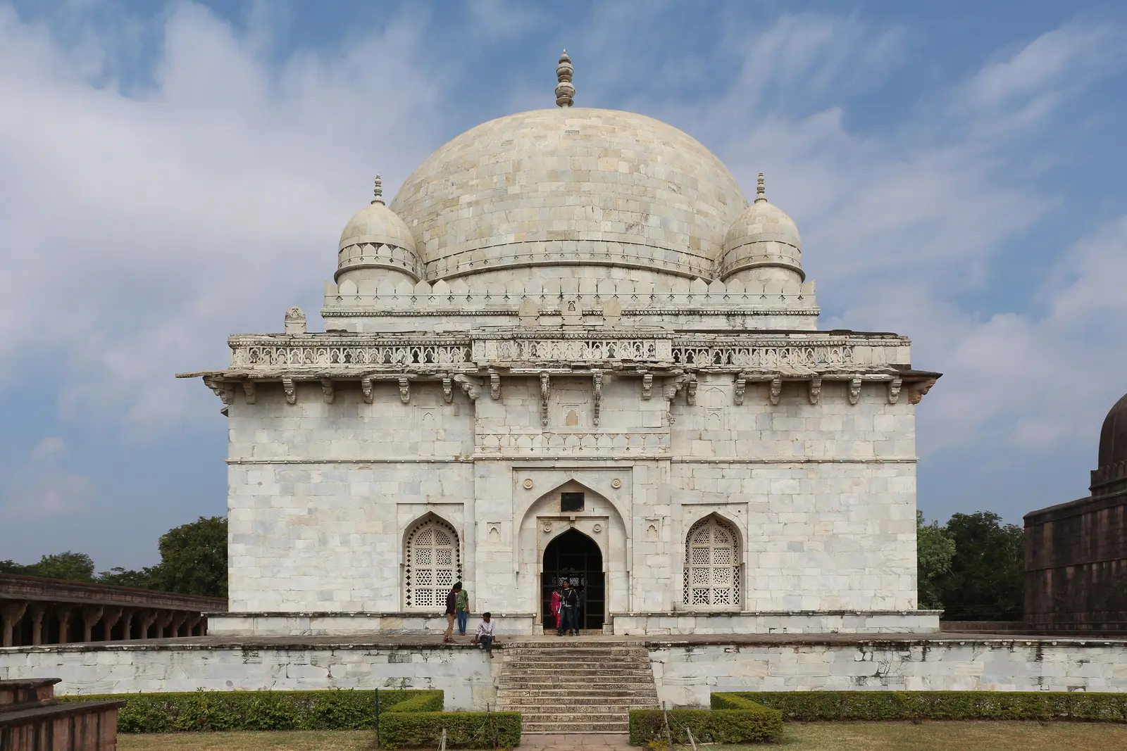 White marble Hoshang Shah's Tomb in Mandu, with a large central dome, four corner cupolas and carved stone lattice windows