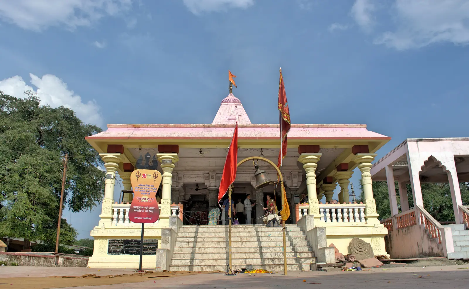 Cream-coloured front of the Kal Bhairav temple in Ujjain, with saffron flags and steps up to the entrance
