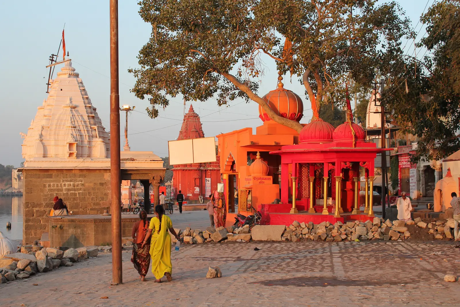 White and saffron-red temple shrines along Ram Ghat on the Shipra river in Ujjain, in evening light